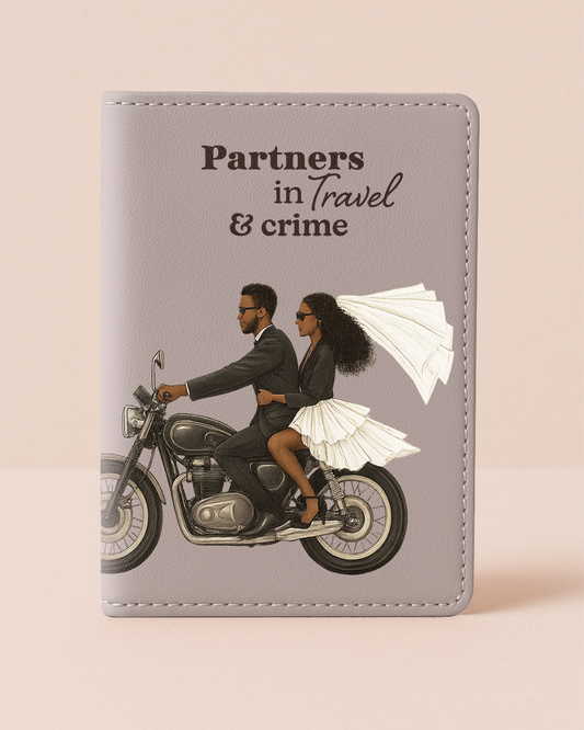 Passport holder with illustration of a couple on a motorcycle and text 'Partners in Travel & crime' on a beige background
